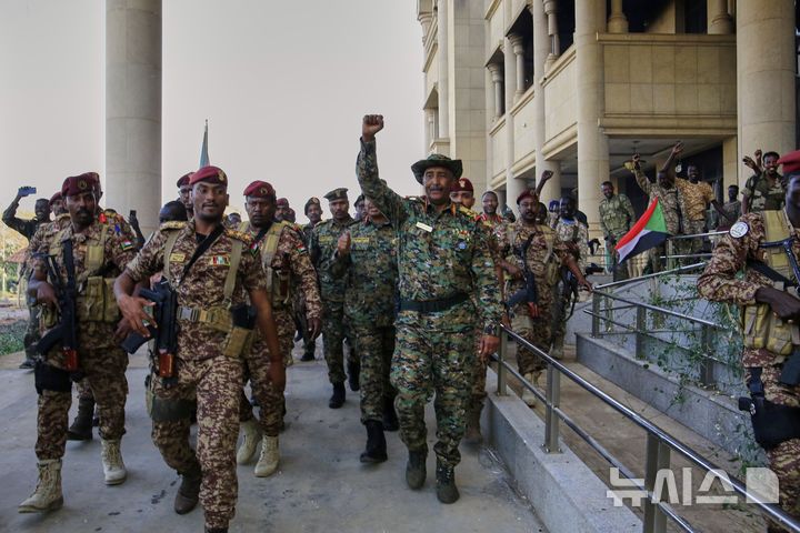 [하르툼=AP/뉴시스] 수단 군부 최고지도자인 압델 파타 부르한(가운데) 장군이 올 해 3월 26일 수도 하르툼에서 반군인 신속지원군(RSF)으로부터 2년만에 탈환한 대통령궁에 도착해 환호하는 군인들에게 화답하고 있다. 2025.03.27.