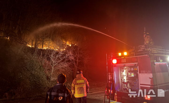 [무주=뉴시스] 김얼 기자 = 27일 전북 무주군 부남면의 한 주택에서 발생한 화재가 인근 산으로 번지자 소방관들이 화재를 진압하고 있다. 2025.03.27. pmkeul@newsis.com