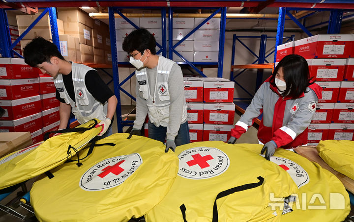[수원=뉴시스] 김종택 기자 = 대한적십자사 경기도지사 직원들이 지난달 27일 경기도 수원시 권선구 남중부봉사관 구호창고에서 산불 피해 지역인 경북 영덕군에 지원할 재난구호 텐트 등 긴급 구호물품을 옮기고 있다. (사진=중부일보 제공) 2025.03.27. photo@newsis.com