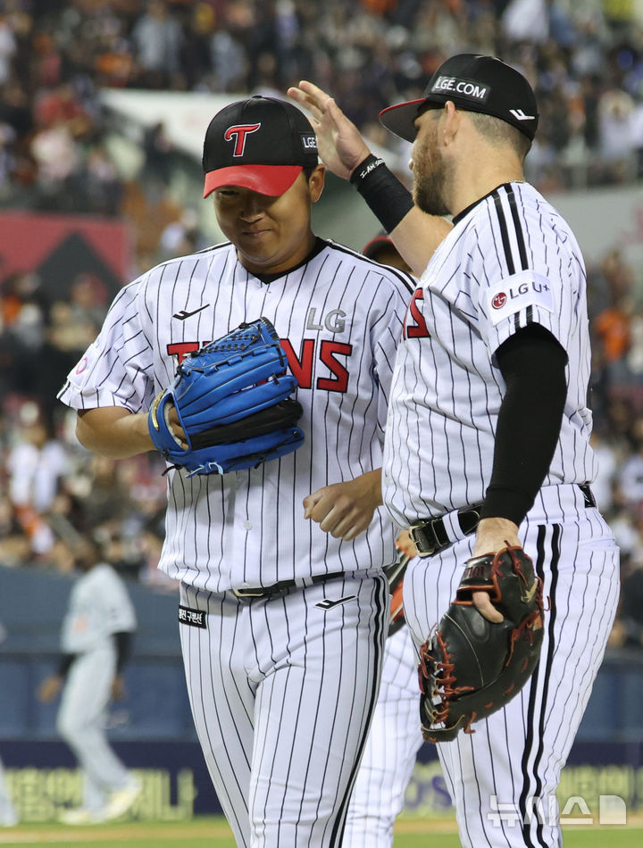 [서울=뉴시스] 김진아 기자 = 27일 오후 서울 송파구 잠실야구장에서 열린 2025 KBO리그 한화 이글스와 LG 트윈스의 경기, 7회초 2사 2루 LG 송승기가 한화 채은성이 3루수 땅볼 아웃되자 더그아웃으로 들어오며 오스틴과 기뻐하고 있다. 2025.03.27. bluesoda@newsis.com