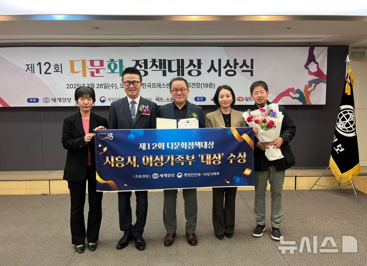 [시흥=뉴시스] '제12회 다문화정책 대상' 시상식에서 대상인 여성가족부 장관상을 받은 직원들이 기념 촬영을 하고 있다. (사진=시흥시 제공).