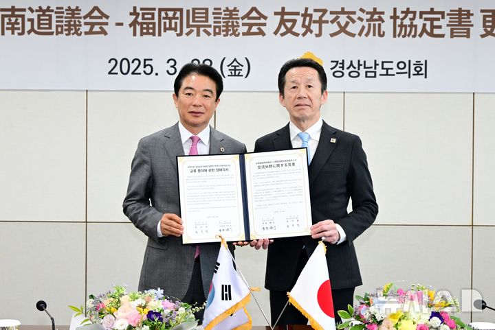 [창원=뉴시스]28일 경상남도의회 회의실에서 최학범(왼쪽) 의장이 일본 후쿠오카현의회 고하라 가츠지 의장과 갱신한 우호교류협정서를 들고 기념촬영하고 있다.(사진=경남도의회 제공) 2025.03.28. photo@newsis.com