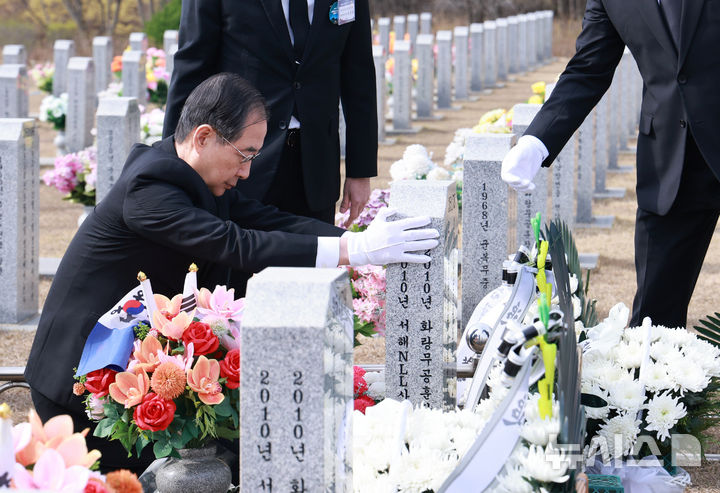 [대전=뉴시스] 최진석 기자 = 한덕수 대통령 권한대행 국무총리가 28일 국립대전현충원 천안함 46용사 묘역에서 고 정종율 상사 묘비를 어루만지고 있다. (대통령실통신사진기자단) 2025.03.28. myjs@newsis.com