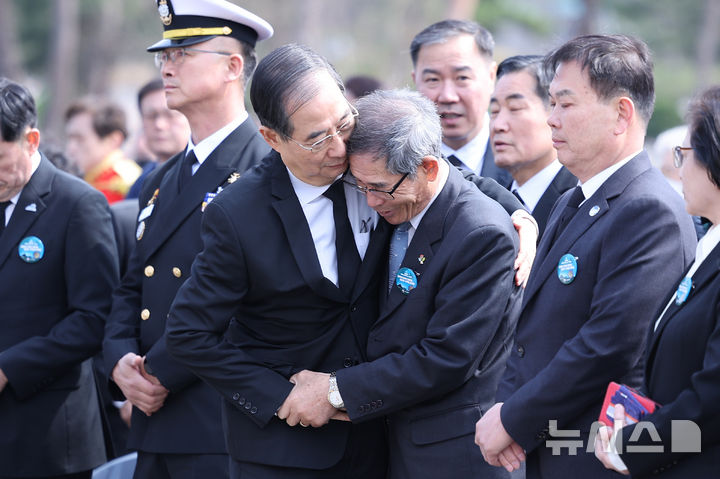 [대전=뉴시스] 최진석 기자 = 한덕수 대통령 권한대행 국무총리가 28일 국립대전현충원에서 열린 제10회 서해수호의 날 기념식에서 서해수호 55용사 유족 서영석 씨를 위로하고 있다. (대통령실통신사진기자단) 2025.03.28. myjs@newsis.com