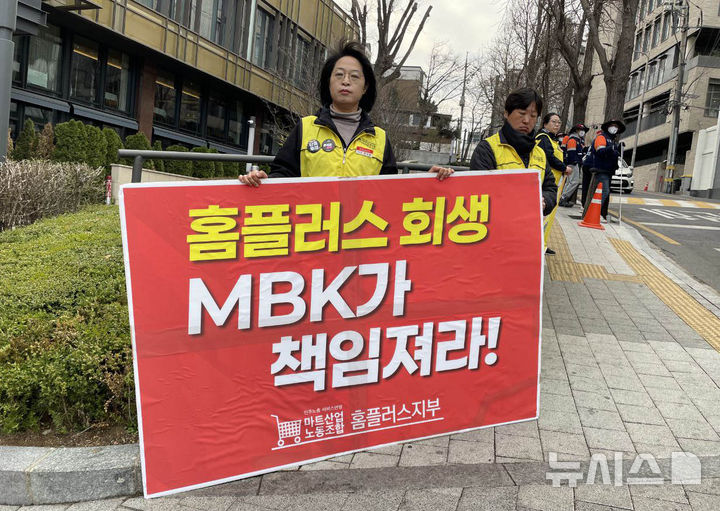[서울=뉴시스] 제51기 고려아연 주주총회가 열린 28일 서울 용산구 몬드리안 호텔 앞에서 민주노총 서비스연맹 마트산업노동조합 홈플러스지부 노조원들이 피켓을 들고 있다. (사진=독자 제공) 2025.03.28. photo@newsis.com
