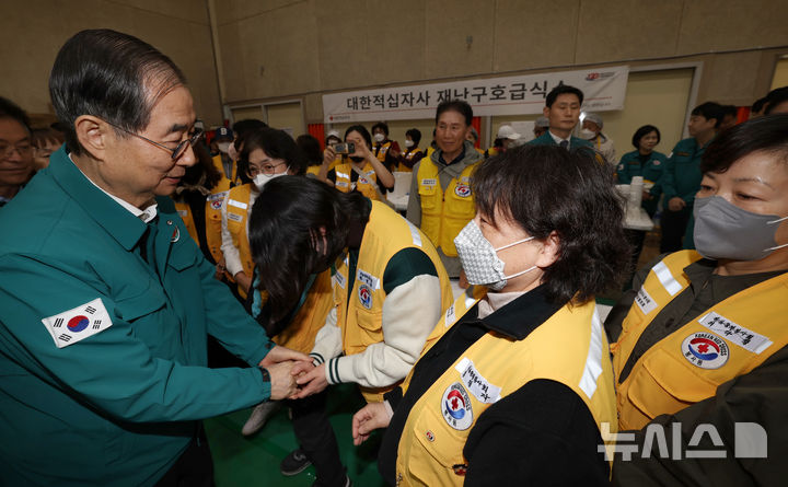 [안동=뉴시스] 최진석 기자 = 한덕수 대통령 권한대행 국무총리가 28일 경북 안동시 안동실내체육관에 마련된 산불 주민대피소에서 대한적십자사 재난구호급식소 봉사자들을 격려하고 있다. 2025.03.28. myjs@newsis.com