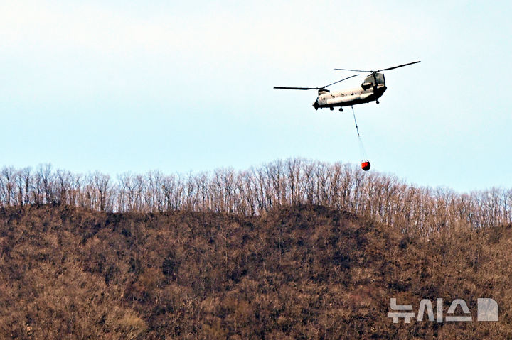 [산청=뉴시스] 차용현 기자 = 경남 산청 산불 발생 10일째로 접어든 30일 오전 군용헬기가 시천면 구곡산 일원에서 진화작업을 펼치고 있다. 2025.03.30. con@newsis.com