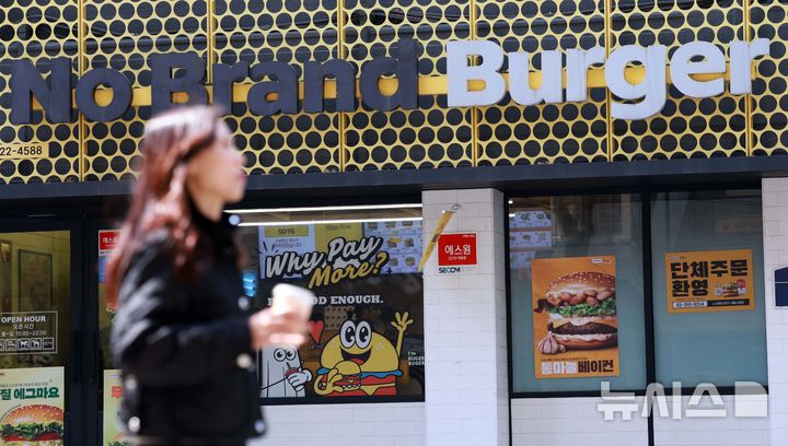 [서울=뉴시스] 고범준 기자 = 서울의 한 노브랜드 버거 매장 앞으로 시민들이 지나가고 있다. 2025.03.31. bjko@newsis.com