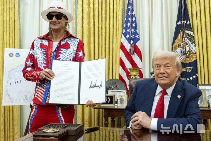 [워싱턴=AP/뉴시스] 가수 키드 락(왼쪽)이 지난달 31일(현지 시간) 백악관 집무실에서 도널드 트럼프 대통령이 서명한 암표 거래 제한 행정 명령을 들고 있다. 이 명령에 따라 암표상들이 컴퓨터 프로그램을 이용해 티켓을 자동으로 대량 구매한 뒤 부당하게 높은 가격에 되파는 것을 막는 ‘BOTS법’이 엄격히 시행될 것으로 보인다. 2025.04.01.