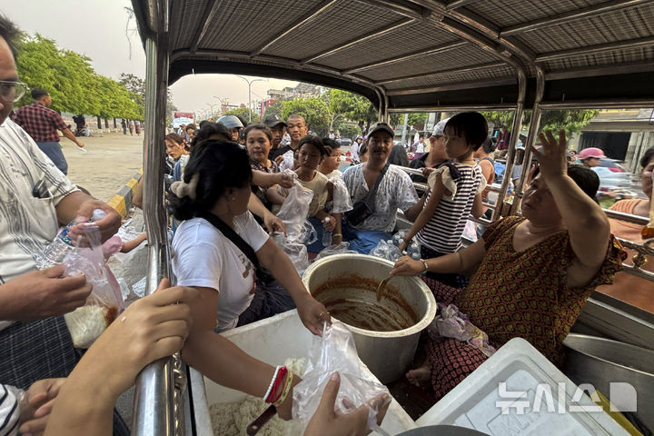 [만달레이=AP/뉴시스] 2일(현지 시간) 미얀마 만달레이 거리에서 지진 피해 이재민들이 물과 음식을 받고 있다. 미얀마 군부는 지난달 28일 발생한 강진의 피해 수습을 위해 반군 세력과 3주간 휴전을 선포했다. 현재까지 사망자 수는 3천 명을 넘어선 것으로 알려졌다. 2025.04.03.
