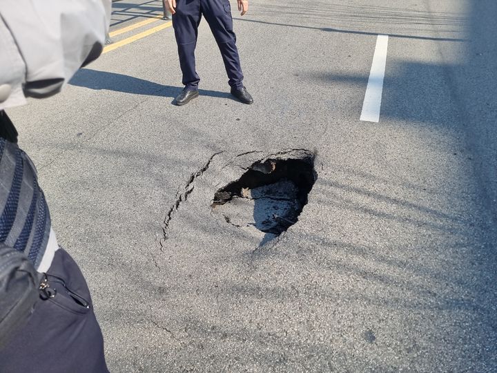 [부산=뉴시스] 2일 오후 3시28분께 부산 사하구 괴정동의 한 도로에 깊이 50㎝, 지름 1m 가량의 싱크홀(땅꺼짐)이 생겼다. (사진=부산경찰청 제공) 2025.04.02. photo@newsis.com *재판매 및 DB 금지