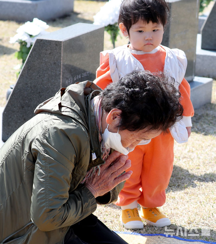 [제주=뉴시스] 우장호 기자 = 제77주년 4·3희생자 추념일을 하루 앞둔 3일 오전 제주시 봉개동 제주4·3평화공원 행방불명인 묘역에서 한 어린이가 할머니의 참배를 지켜보고 있다. 2025.04.02. woo1223@newsis.com