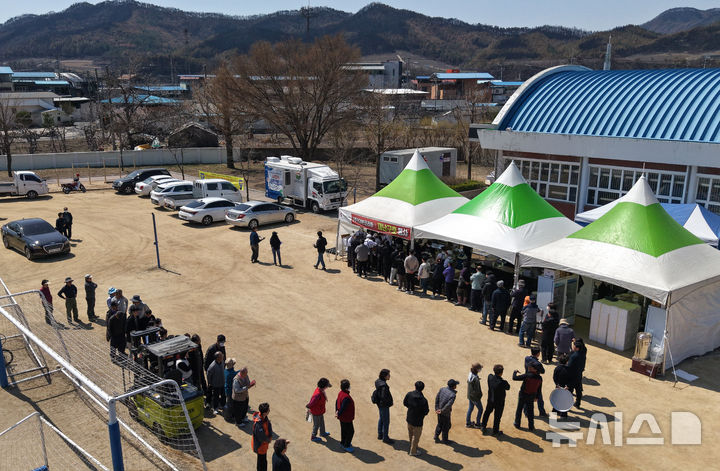 [안동=뉴시스] 이무열 기자 = 2일 경북 안동시 길안면 길안중학교 운동장에서 산불 피해를 입은 이재민들이 점심 배식을 받기 위해 줄을 서고 있는 모습. 2025.04.02. lmy@newsis.com