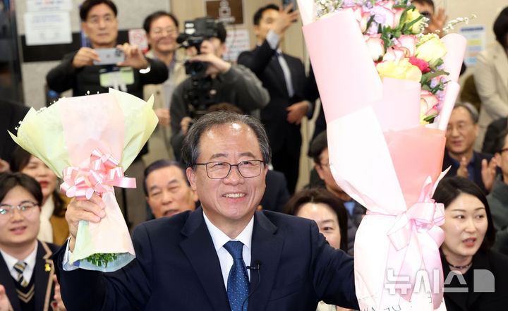 [부산=뉴시스] 하경민 기자 = 부산교육감 재선거 투표일인 2일 부산 부산진구 김석준 후보 선거사무소에서 김 후보가 당선이 유력해지자 꽃다발을 들고 지지자들에게 인사하고 있다. 2025.04.02. yulnetphoto@newsis.com