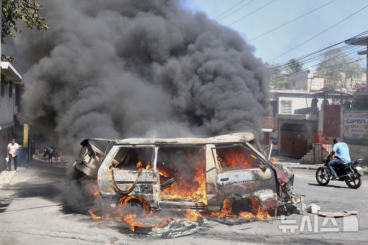 [포르토프랭스=AP/뉴시스]&nbsp; 아이티 포르토프랭스에서 4월 2일 치안 불안에 항의하는 반정부 시위대가 방화한 차량이 짙은 연기를 내뿜으며 불에 타고 있다. 2025.04.03.