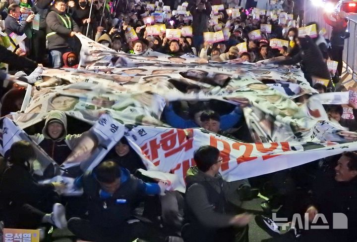 [제주=뉴시스] 오영재 기자 = 윤석열 대통령 탄핵 심판 선고 전날인 3일 오후 제주시청에서 열린 '윤석열 파면 촉구 제주도민대회'에서 주최 측인 윤석열정권퇴진 한국사회대전환 제주행동이 탄핵 반대 국회의원 92인의 현수막을 찢는 퍼포먼스를 하고 있다. 2025.04.03. oyj4343@newsis.com