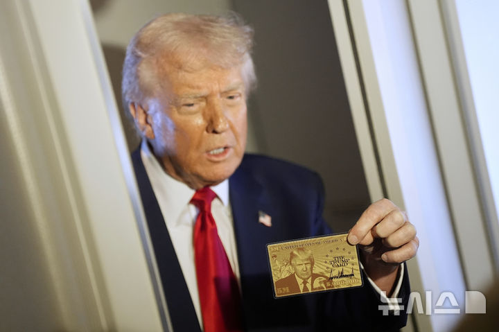 [에어포스원=AP/뉴시스] 도널드 트럼프 미국 대통령이 3일(현지 시간) 플로리다 마이애미로 향하는 에어포스원에서 취재진에 '골드 카드'를 들어 보이고 있다. 2025.04.04.