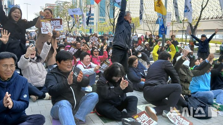 [대전=뉴시스] 조명휘 기자 = 4일 오전 대전 서구 둔산동 은하수네거리에서 헌법재판소의 윤석열 대통령 탄핵심판 선고를 시청하던 시민들이 탄핵선고 주문이 내려지자 환호하고 있다. 2025.04.04. photo@newsis.com