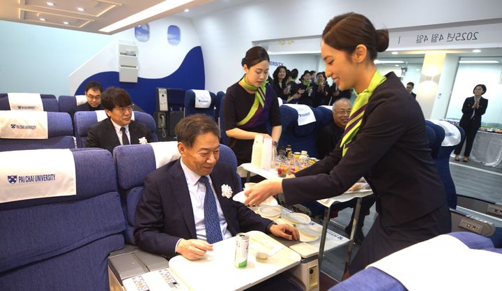 [대전=뉴시스] 제2 항공모형비행실습실 개관식에서 객실 서비스 실습에 응하고 있는 배재대 김욱 총장. (사진=배재대 제공) *재판매 및 DB 금지