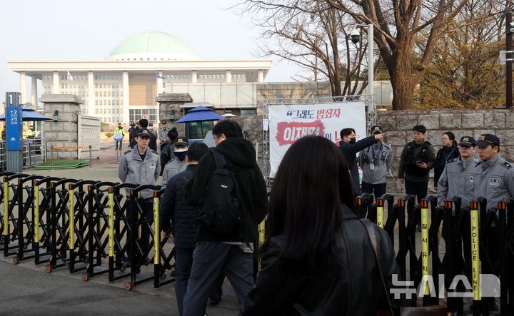 [서울=뉴시스] 조성봉 기자 = 헌법재판소의 윤석열 대통령 탄핵소추안 선고일인 4일 오전 서울 여의도 국회 입구에서 경찰이 경계근무를 강화하고 있다. 2025.04.04. suncho21@newsis.com 