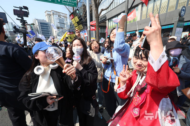[서울=뉴시스] 김명년 기자 = 윤석열 대통령이 파면된 4일 오전 서울 종로구 헌법재판소 인근 안국역 6번출구 앞에서 열린 집회 참가자들이 기뻐하고 있다. 2025.04.04. kmn@newsis.com