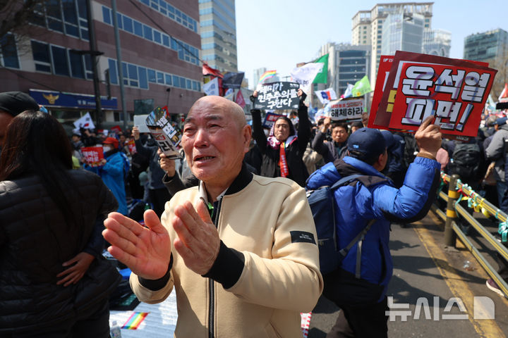 [서울=뉴시스] 김명년 기자 = 윤석열 대통령이 파면된 4일 오전 서울 종로구 헌법재판소 인근 안국역 6번출구 앞에서 열린 집회 참가자들이 기뻐하고 있다. 2025.04.04. kmn@newsis.com