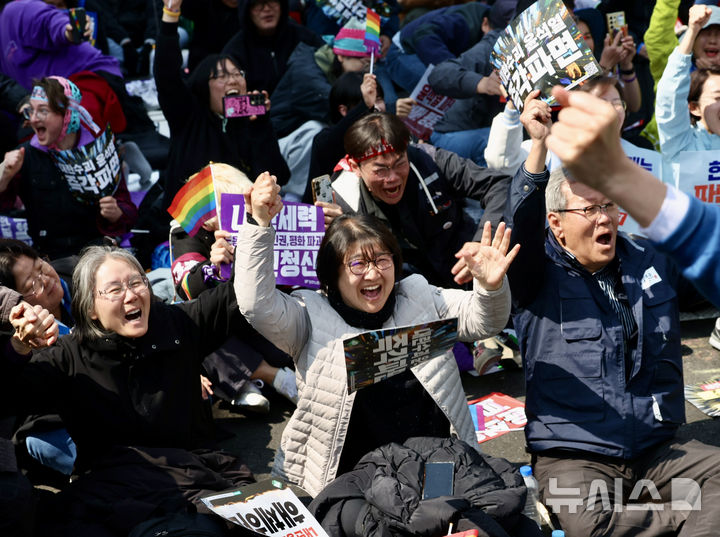 [서울=뉴시스] 김명년 기자 = 윤석열 대통령이 파면된 4일 오전 서울 종로구 헌법재판소 인근 안국역 6번출구 앞에서 열린 집회 참가자들이 기뻐하고 있다. 2025.04.04. kmn@newsis.com