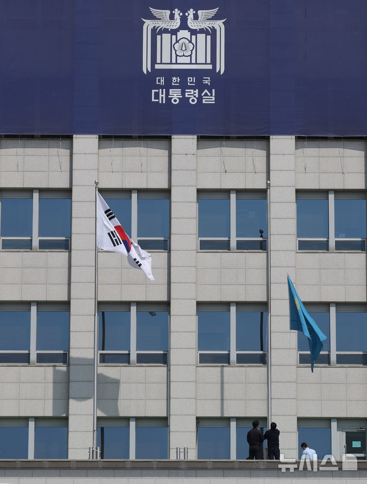 [서울=뉴시스] 조수정 기자 = 헌법재판소가 윤석열 대통령의 탄핵사건에 대해 인용을 선고한 4일 서울 용산 대통령실 청사에서 관계자들이 봉황기를 하기하고 있다. 2025.04.04. chocrystal@newsis.com