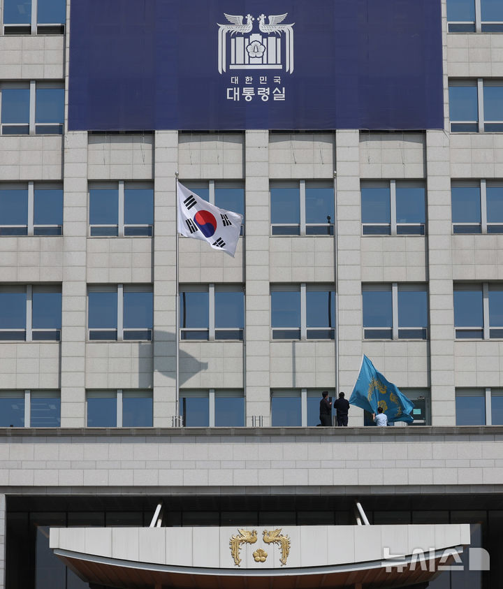 [서울=뉴시스] 조수정 기자 = 헌법재판소가 윤석열 대통령의 탄핵사건에 대해 인용을 선고한 4일 서울 용산 대통령실 청사에서 관계자들이 봉황기를 하기하고 있다. 2025.04.04. chocrystal@newsis.com