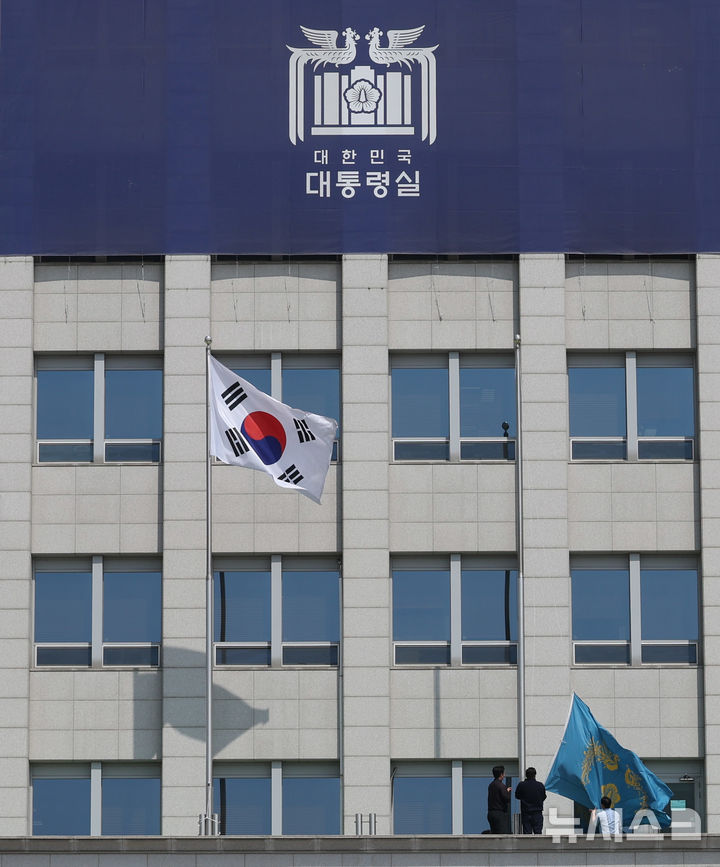 [서울=뉴시스] 조수정 기자 = 헌법재판소가 윤석열 대통령의 탄핵사건에 대해 인용을 선고한 4일 서울 용산 대통령실 청사에서 관계자들이 봉황기를 하기하고 있다. 2025.04.04. chocrystal@newsis.com