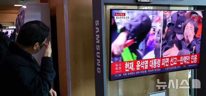 [서울=뉴시스] 박주성 기자 = 4일 오전 서울 용산구 서울역 역사에서 시민이 윤석열 대통령 탄핵심판 선고를 시쳥하고 있다. 2025.04.04. park7691@newsis.com