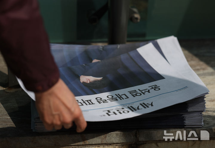 [서울=뉴시스] 김진아 기자 = 헌법재판소가 윤석열 전 대통령 파면을 선고한 4일 오후 서울 광화문역에서 시민들이 선고 관련 호외를 집어들고 있다. 2025.04.04. bluesoda@newsis.com