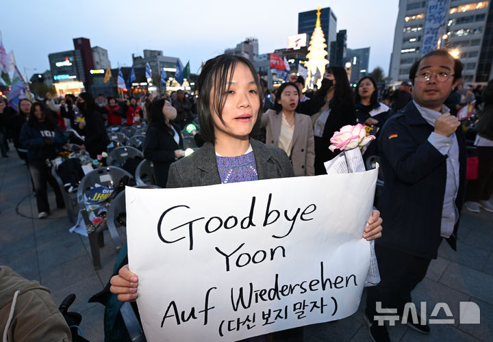 [광주=뉴시스] 김혜인 기자 = 윤석열 대통령이 파면된 4일 오후 광주 동구 5·18민주광장에서 열린 광주시민 승리대회에서 한 참석자가 파면 환영 문구를 들고 있다. 2025.04.04.hyein0342@newsis.com