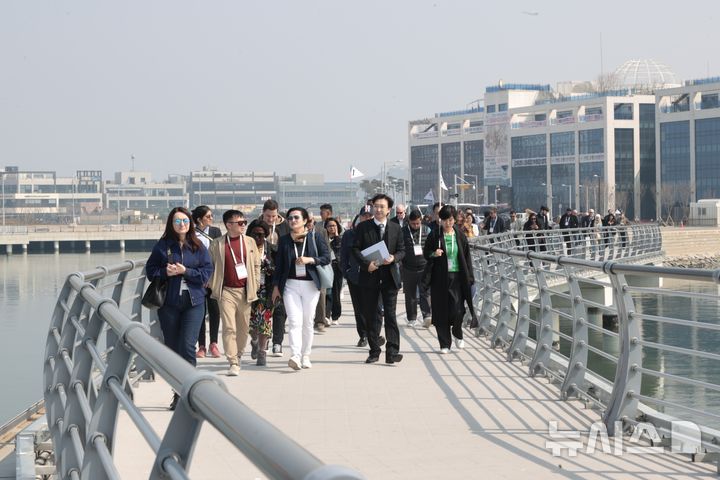 [시흥=뉴시스] 세계기자 대회에 참석한 52개국 언론인들이 시흥시를 방문한 가운데 시흥시가 자랑하는 경관 브리지를 거닐고 있다. (사진=시흥시 제공).