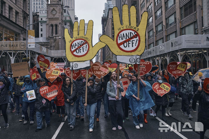 [뉴욕=AP/뉴시스] 5일(현지 시간) 미국 뉴욕에서 도널드 트럼프 대통령과 일론 머스크 정부효율부 수장에 반대하는 '핸즈 오프!'(Hands Off!) 집회가 열려 참가자들이 구호를 외치며 행진하고 있다. 이날 미국 전역에서 손을 떼라는 의미의 '핸즈 오프' 시위와 행진이 열려 민권 단체, 노동조합, 성소수자 권익 옹호 단체와 참전용사 단체 등이 참여했다. 2025.04.06.