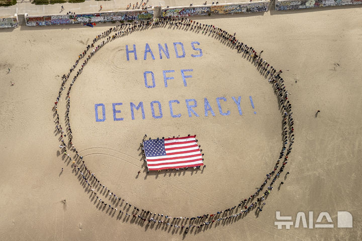 [샌프란시스코=AP/뉴시스] 5일(현지 시간) 미 샌프란시스코 오션 비치에서 도널드 트럼프 대통령과 일론 머스크 정부효율부 수장에 반대하는 '핸즈 오프!'(Hands Off!) 집회가 열려 참가자들이 퍼포먼스를 하고 있다. 이날 미국 전역에서 손을 떼라는 의미의 '핸즈 오프' 시위와 행진이 열려 민권 단체, 노동조합, 성소수자 권익 옹호 단체와 참전용사 단체 등이 참여했다. 2025.04.06.