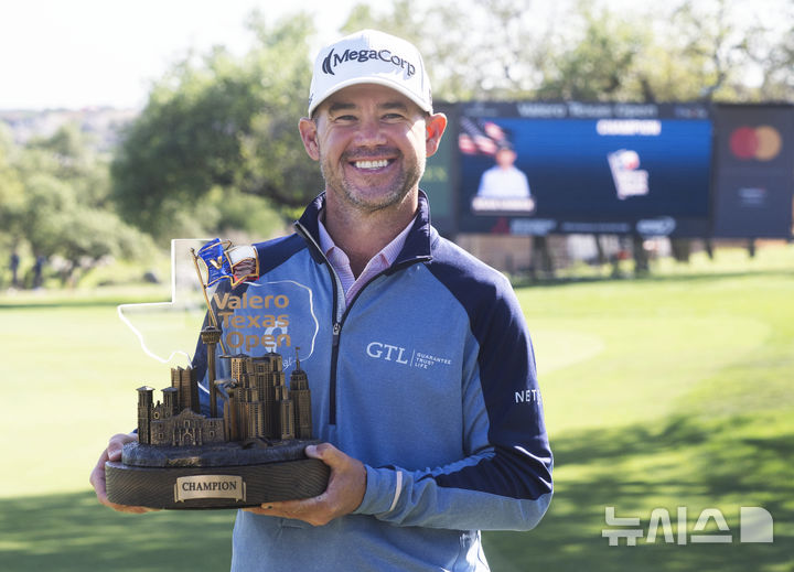 [샌안토니오=AP/뉴시스] 브라이언 하먼(미국)이 6일(현지 시간) 미 텍사스주 샌안토니오의 TPC 샌안토니오에서 열린 미국프로골프(PGA) 투어 발레로 텍사스 오픈 정상에 올라 트로피를 들고 포즈를 취하고 있다. 하먼은 최종 합계 9언더파 279타로 우승, 투어 통산 4승째를 기록했다. 2025.04.07.