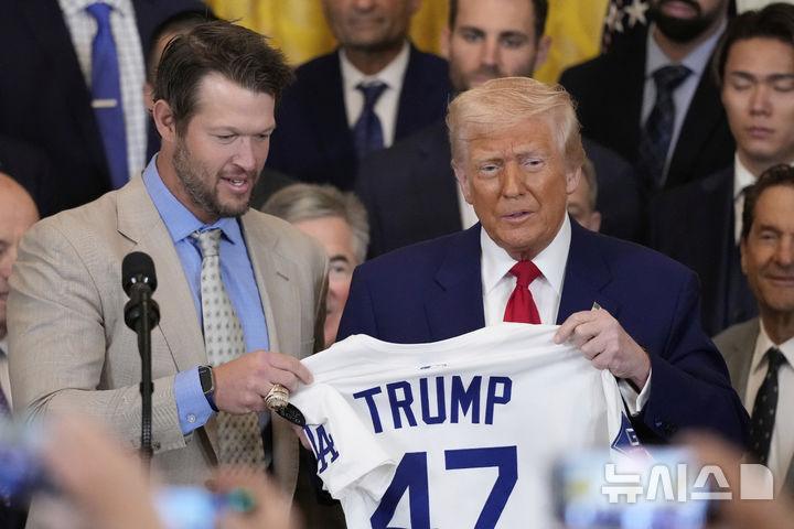 [워싱턴=AP/뉴시스] 도널드 트럼프(오른쪽) 미국 대통령이 7일(현지 시간) 백악관 이스트룸에서 열린 2024 메이저리그 월드시리즈 우승 팀 로스앤젤레스 다저스 축하 행사에서 클레이튼 커쇼로부터 유니폼을 선물 받고 있다. 2025.04.08.