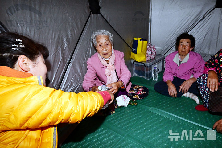 [하동=뉴시스] 차용현 기자 = 경남 하동군 옥종면 산불 발생 2일째를 맞은 8일 오전 옥종고등학교에 마련된 산불 대피소에서 한 자원봉사자가 산불을 피해 대피한 어르신에게 물을 따라주고 있다. 2025.04.08. con@newsis.com