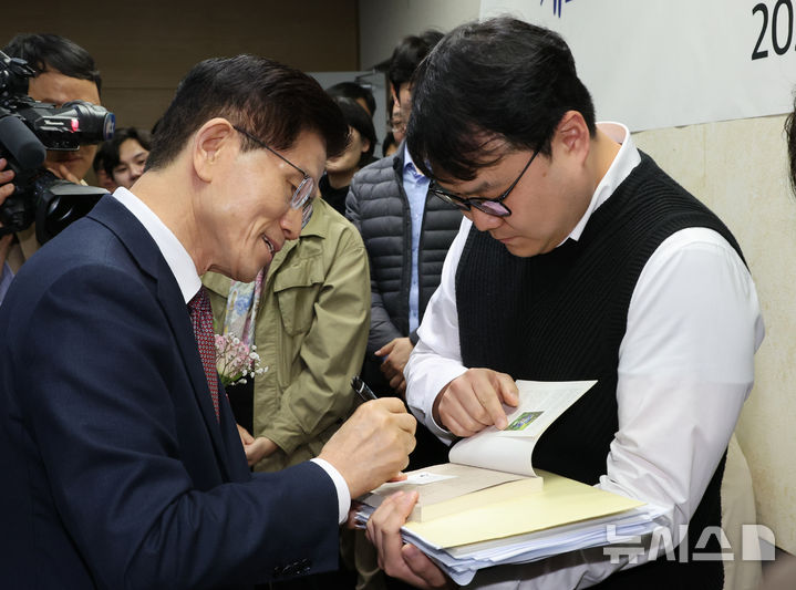 [세종=뉴시스] 강종민 기자 = 김문수 고용노동부 장관이 8일 세종시 정부세종청사에서 열린 이임식에서 한 직원이 요청으로 사인을 하고 있다. 2025.04.08. ppkjm@newsis.com