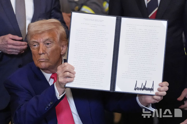 [워싱턴=AP/뉴시스] 8일(현지 시간) 월스트리트저널에 따르면 상공회의소, 소비자기술협회 등은 1970년대 제정된 '국제비상경제권법(IEEPA)'을 도널드 트럼프 미국 대통령이 잘못 적용해 과도한 관세를 부과했다는 내용의 소송을 준비 중이다. 도널드 트럼프 미국 대통령이 8일(현지 시간) 백악관 이스트룸에서 석탄 산업 활성화 행정명령에 서명한 후 이를 들어 보이고 있다. 2025.04.09.