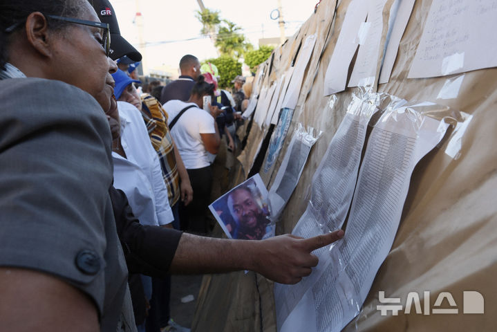 [산토도밍고=AP/뉴시스] 8일(현지 시간) 도미니카공화국 산토도밍고의 나이트클럽 지붕 붕괴 현장에서 실종자 가족들이 명단을 확인하고 있다. 현지 경찰은 이날 '제트세트' 나이트클럽에서 가수의 공연 도중 지붕이 무너져 공연 관람 중이던 현직 주지사 포함 최소 44명이 숨지고 100여 명이 다쳤다고 밝혔다. 2025.04.09.