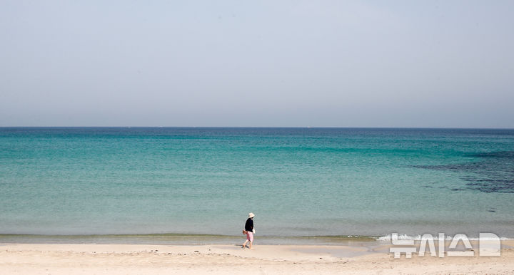 [제주=뉴시스] 우장호 기자 = 포근한 날씨를 보인 9일 오전 제주시 조천읍 함덕해수욕장에서 한 관광객이 해변을 따라 산책을 하고 있다. 2025.04.09. woo1223@newsis.com