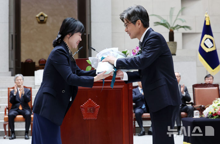 [서울=뉴시스] 이영환 기자 = 마용주 대법관이 9일 오전 서울 서초구 대법원에서 열린 취임식에서 직원에게 꽃다발을 받고 있다. 2025.04.09. 20hwan@newsis.com