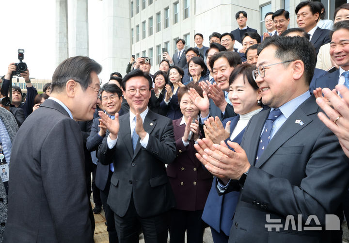 [서울=뉴시스] 권창회 기자 = 이재명 더불어민주당 전 대표가 9일 오전 서울 여의도 국회에서 대표직 사퇴 후 박찬대 원내대표와 최고위원 등 의원들과 기념촬영을 하고 국회를 나서며 박수를 받고 있다. (공동취재) photo@newsis.com