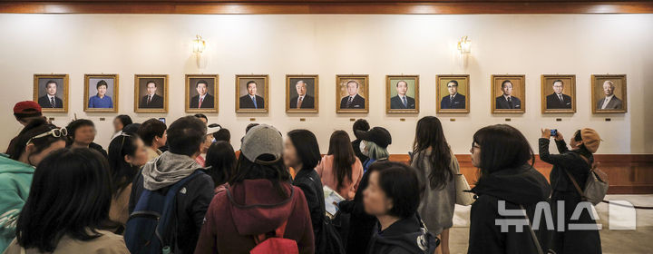 [서울=뉴시스] 정병혁 기자 = 9일 서울 종로구 청와대를 찾은 관람객들이 본관 세종실에 설치된 역대 대통령 초상화를 살펴보고 있다.윤석열 전 대통령에 대한 헌법재판소의 탄핵 선고 후 청와대를 찾는 발길이 늘어나고 있다. 광화문 등 인근에서 이어지던 탄핵 시위가 멈춘 데다, 조기 대선 후 대통령 집무실의 청와대 복귀 가능성도 나오는데 따른 변화로 읽힌다. 2025.04.09. jhope@newsis.com