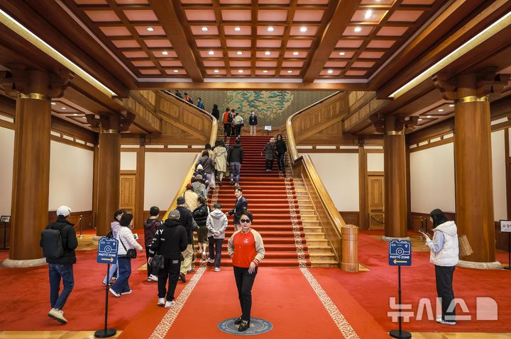[서울=뉴시스] 정병혁 기자 = 9일 서울 종로구 청와대를 찾은 관람객들이 본관에서 사진을 찍고 있다. 윤석열 전 대통령에 대한 헌법재판소의 탄핵 선고 후 청와대를 찾는 발길이 늘어나고 있다. 광화문 등 인근에서 이어지던 탄핵 시위가 멈춘 데다, 조기 대선 후 대통령 집무실의 청와대 복귀 가능성도 나오는데 따른 변화로 읽힌다. 2025.04.09. jhope@newsis.com