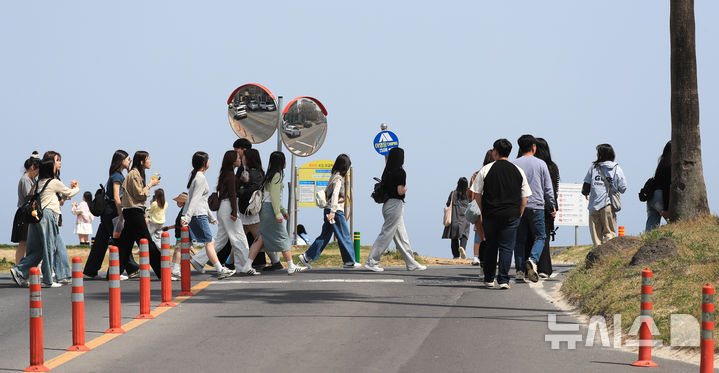 [제주=뉴시스] 우장호 기자 = 봄기운이 완연한 9일 오전 제주시 조천읍 함덕해수욕장 인근 도로에 수학여행을 온 학생들이 무리지어 길을 건너고 있다. 2025.04.09. woo1223@newsis.com