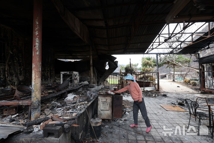 [안동=뉴시스] 김금보 기자 = 산불 피해 주민 박경숙(67)씨가 9일 경북 안동시 길안면 만음리의 전소된 집 마당에서 집기를 살펴보고 있다. 2025.04.09. kgb@newsis.com