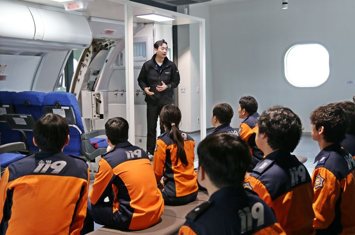 [부산=뉴시스] 지난 9일 에어부산 사옥 훈련시설에서 부산소방재난본부 소방관들이 비상구 조작법을 배우고 있다. (사진=에어부산 제공) 2025.04.10. photo@newsis.com *재판매 및 DB 금지